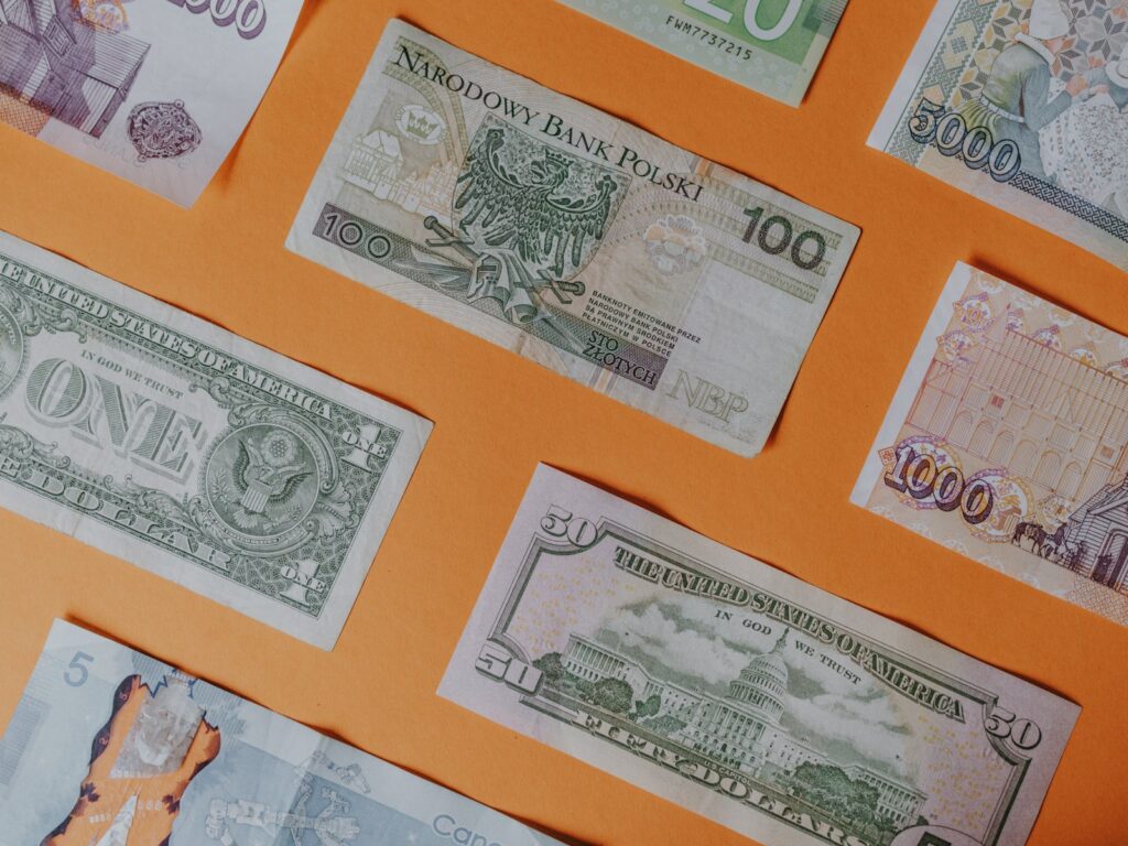 Verschiedene Banknoten auf orangefarbenem Untergrund