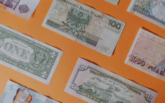 Verschiedene Banknoten auf orangefarbenem Untergrund