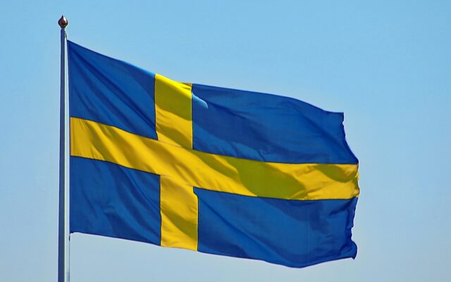 Die blau-gelbe Flagge Schwedens weht vor dem Himmel