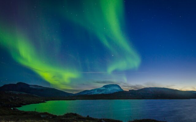Polarlicht über einem Bergsee im Abisko-Nationalpark
