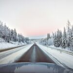 Auto auf einer schneebedeckten Straße bei Umeå in Nordschweden