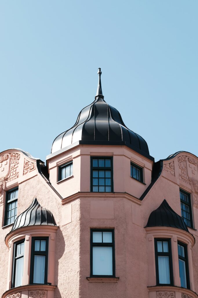 Großes rosa Gebäude mit schwarzem Dach und Erkerfenster in Lund