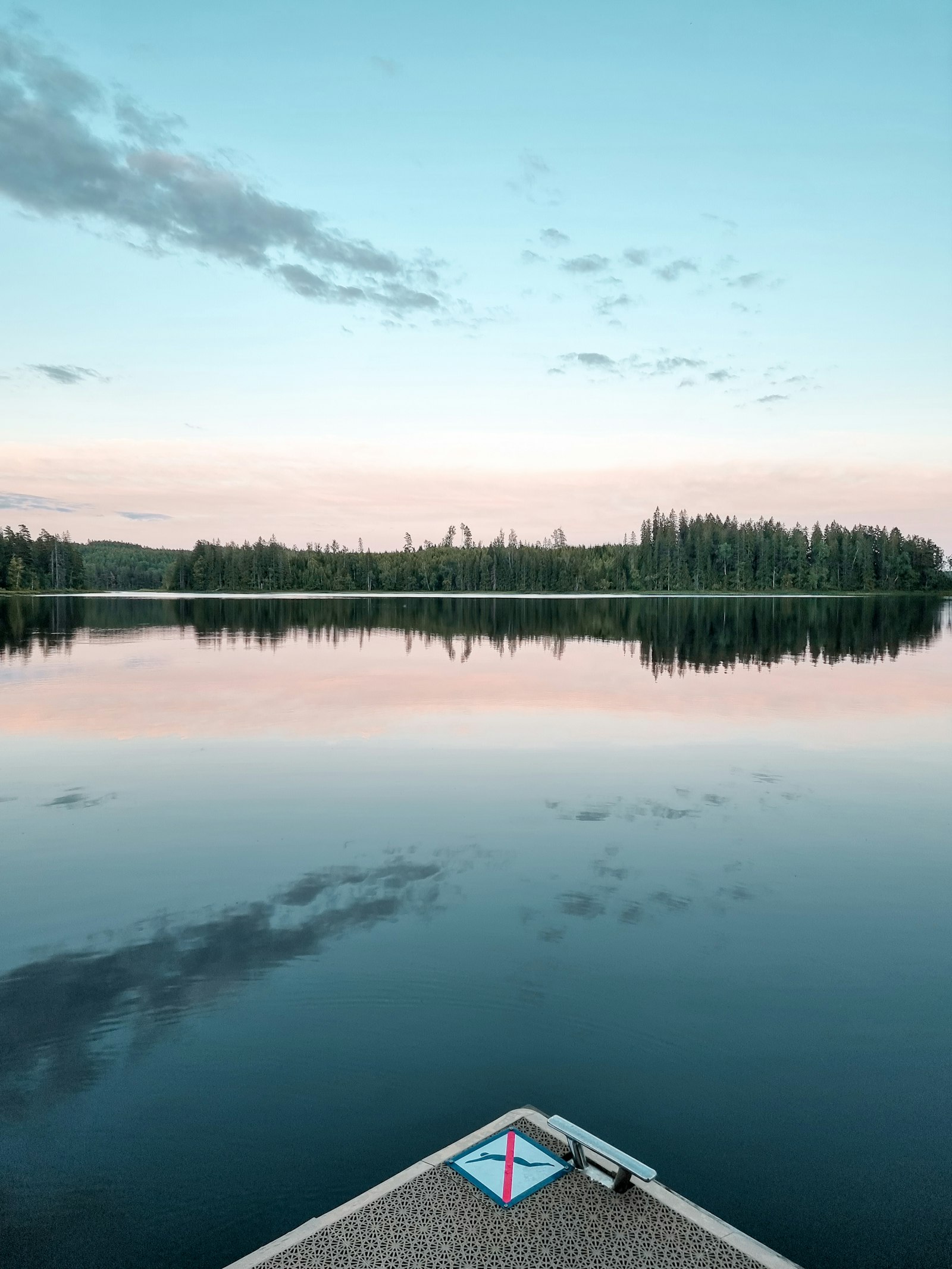 Rolig sø i Smålands skovrige landskab i aftenskumringen