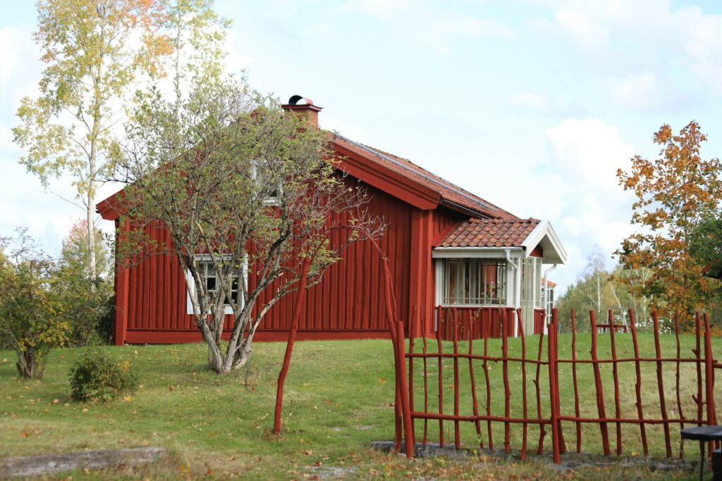 Städte und Regionen 1 Rotes Holzhaus mit rotem Zaun in Kvinnersta, Örebro, Schweden