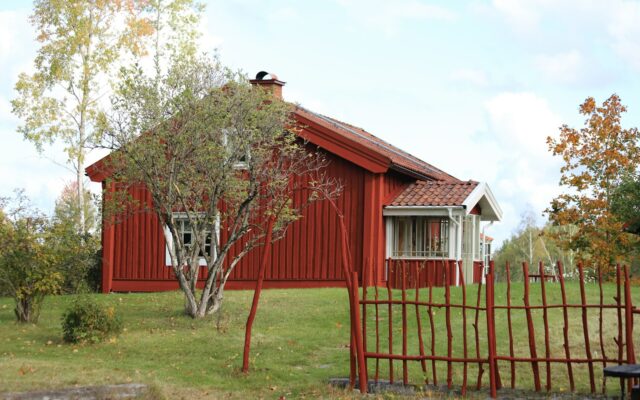 Rotes Holzhaus mit rotem Zaun in Kvinnersta, Örebro, Schweden