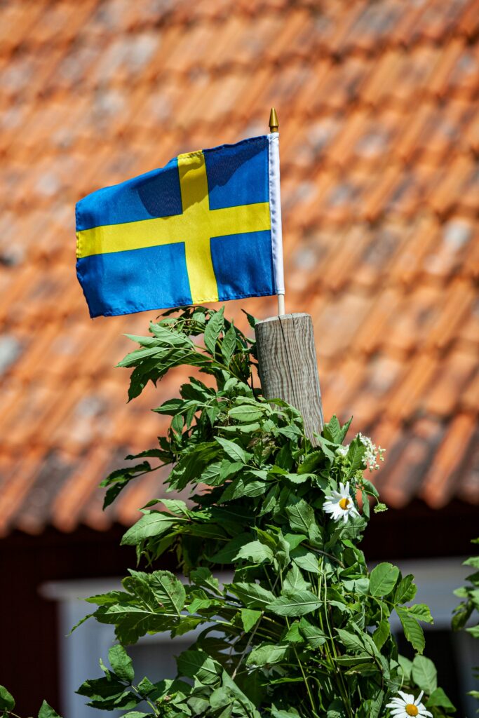 Midsommer i Sverige: sådan fejrer svenskerne lysets fest 1 Schwedische Flagge auf der Spitze einer Midsommarstange auf Öland