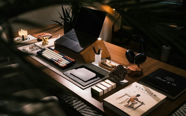 Moderner Schreibtisch mit Laptop, Büchern und Kopfhörern
