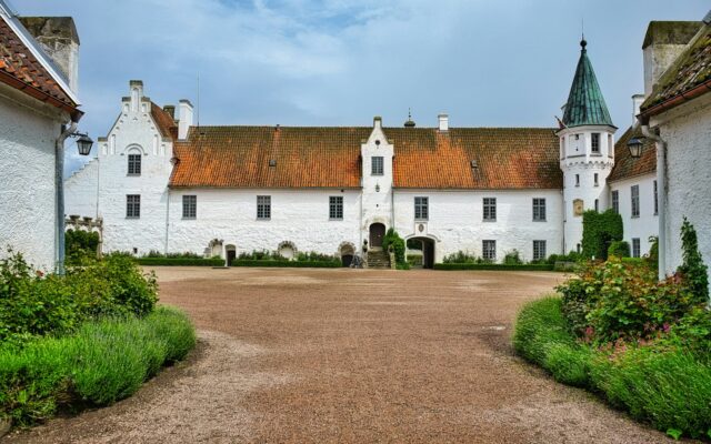 Weißes Schloss mit rotem Dach und grünem Turm, Bosjökloster in Skåne